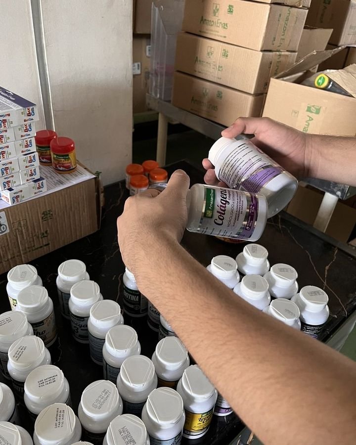Mãos conferindo frascos na separação de um pedido